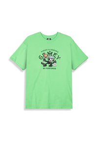 Camiseta de algodón verde con un corte relajado. Presenta un gráfico impreso de personajes con el texto "FUEGO & SAQUEO" y "80 FOSFOROS" en negro.