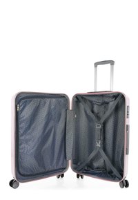 Maleta rígida en rosa pálido; el interior presenta un patrón hexagonal en azul oscuro, correas cruzadas y un compartimento con cremallera para la organización.