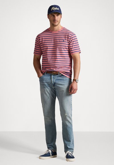 Ριγέ μπλουζάκι σε ροζ και ναυτικό, συνδυασμένο με ανοιχτό μπλε τζην με φθορές. Φορεμένο με ναυτική καπέλο και ναυτικά sneakers. Casual εφαρμογή.