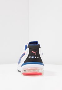 Baskets blanches avec des touches bleues, noires et rouges, dotées d'une semelle à coussin d'air visible et du marquage "CELL" avec le logo Puma au talon.
