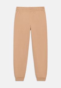 Beige-huonehousut, joissa on elastinen vyötärö, kapenevat hihansuut ja pehmeä rakenne. Yksinkertainen muotoilu, sopii rentoon pukeutumiseen tai oleskeluun.