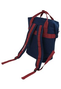 Mochila azul marino con correas color burdeos, que cuenta con un cierre de cremallera, dos asas de transporte y correas de hombro ajustables y acolchadas con textura de malla.