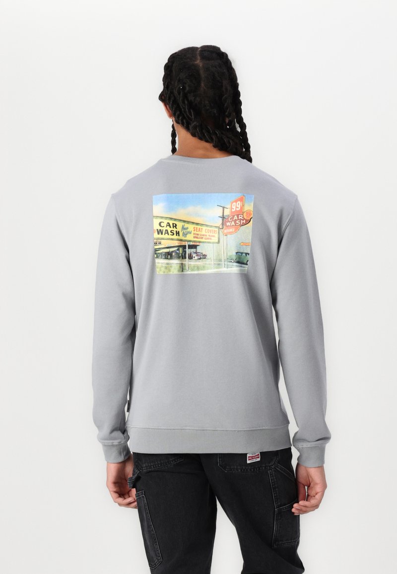 Grauer Sweatshirt mit einem bunten Autowasch-Graphic auf der Rückseite. Gerippte Bündchen und Saum, lässige Passform, weiches Baumwollmischmaterial.