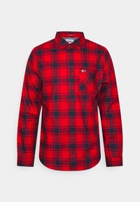 Chemise à manches longues à carreaux rouge et bleu marine avec poche poitrine et col classique, étiquetée "Tommy Jeans" à l'intérieur du col.