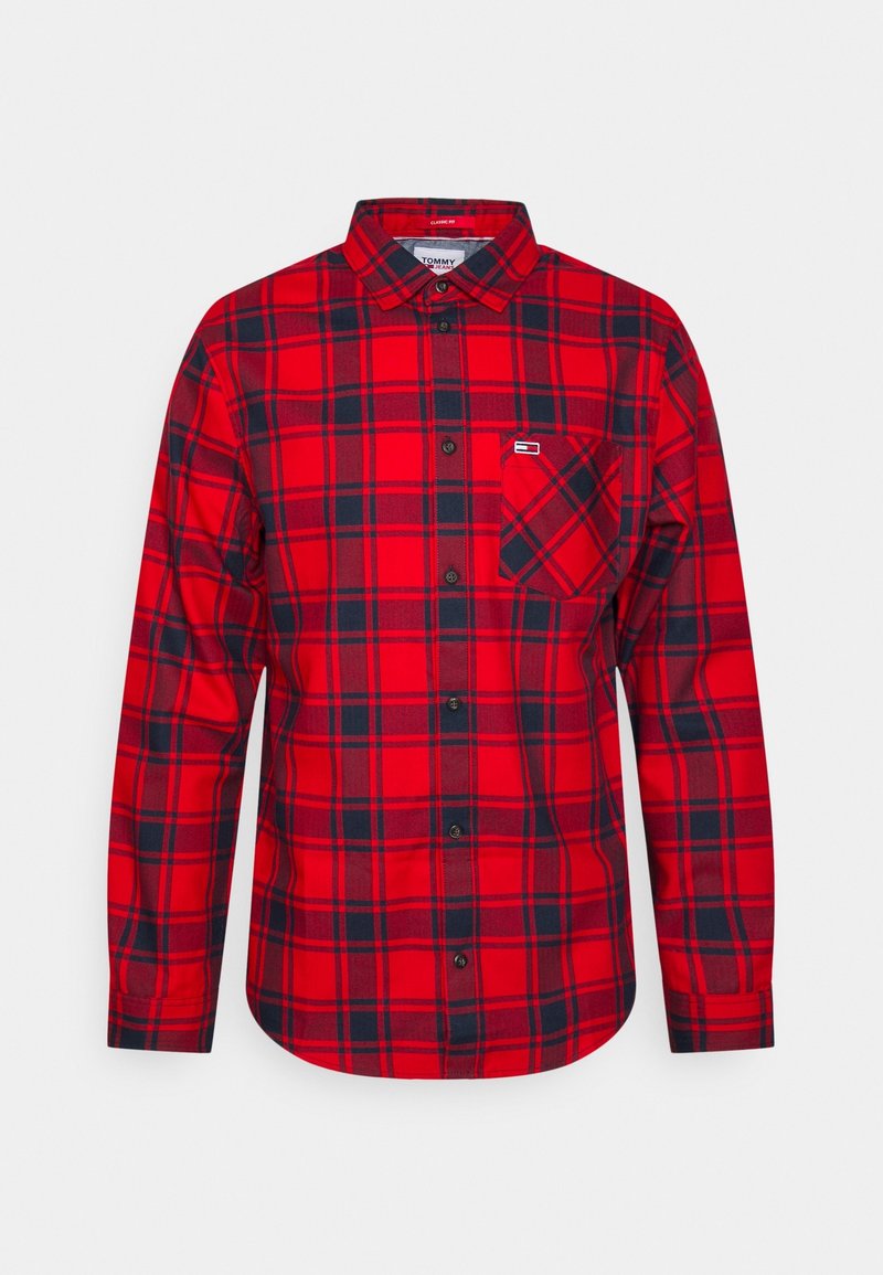 Chemise à manches longues à carreaux rouge et bleu marine avec poche poitrine et col classique, étiquetée "Tommy Jeans" à l'intérieur du col.