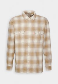 Camicia a quadri marrone e crema con maniche lunghe, colletto button-down, due tasche sul petto e un'etichetta con il logo Levi's sulla tasca sinistra. Mistura di cotone.