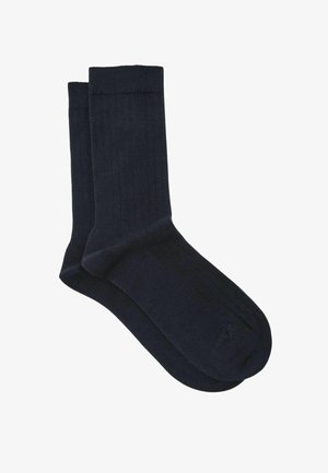 Pair of plain dark navy crew socks with ribbed cuffs, made from soft knit fabric, displayed on a white background.