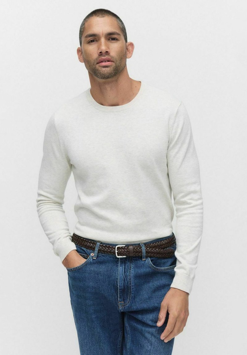 Ljusgrå långärmad tröja med rundad halsringning, kombinerad med blå jeans och ett brunt flätat bälte. Enkelt design, mjuk textur.
