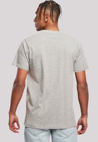 Graues Baumwoll-T-Shirt mit rundem Halsausschnitt, kurzen Ärmeln und glatter Textur. Das Design auf der Rückseite ist einfach, ohne Muster oder Logos.