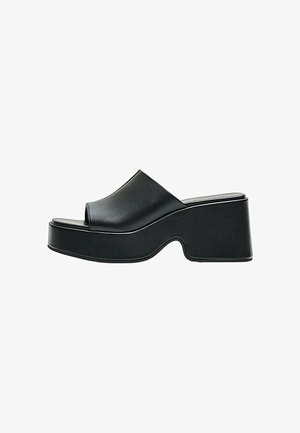 Sort åben tå platform mule med en chunky hæl og en glat læderoverdel, vist fra siden på en hvid baggrund.