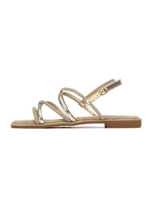 Sandalia dorada con tiras, adornos de pedrería, suela plana y correa ajustable en el tobillo. Acabado metálico suave y plantilla marrón suave.