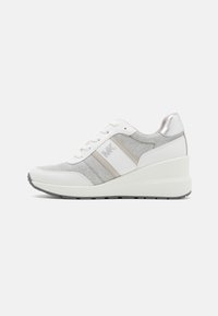 Sneaker bianca con pannelli in tessuto grigio, dettagli metallici argento, lacci piatti e una suola spessa a strati per un aumento di altezza.