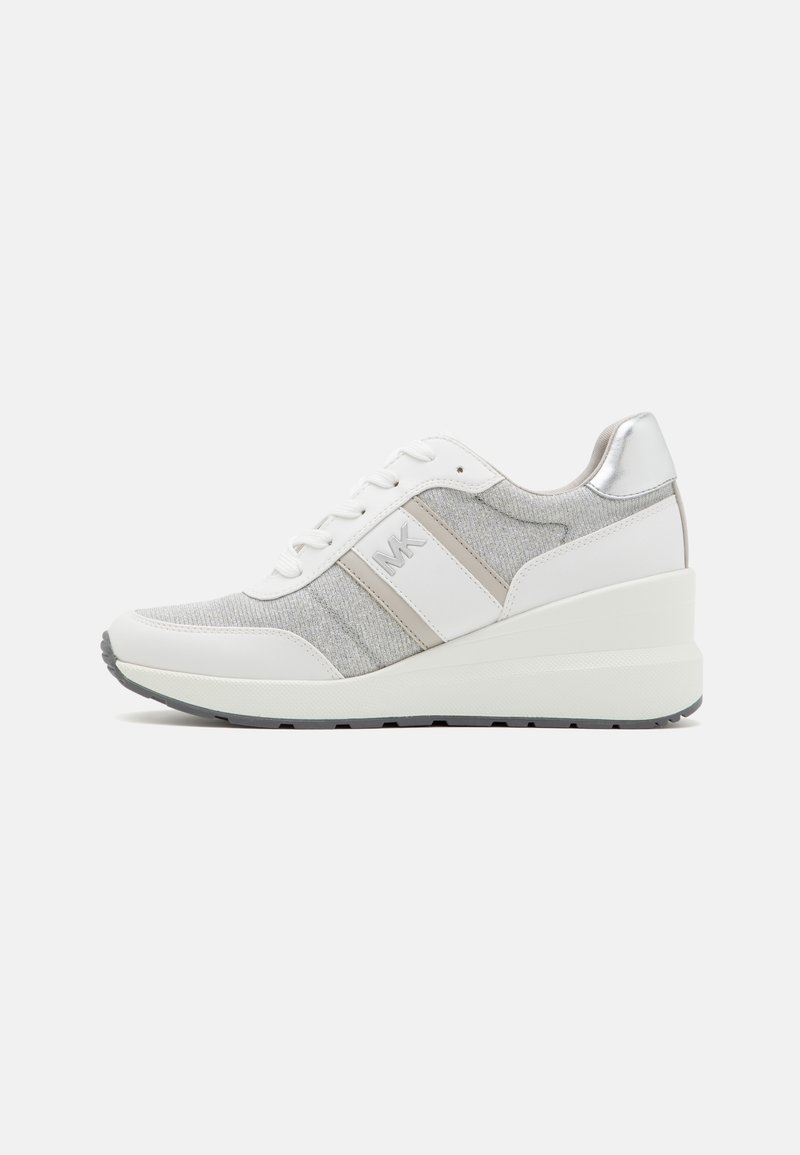 Sneaker bianca con pannelli in tessuto grigio, dettagli metallici argento, lacci piatti e una suola spessa a strati per un aumento di altezza.