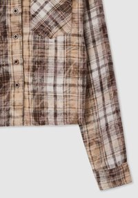 Camicia a quadri marrone e beige realizzata in tessuto morbido. Presenta una chiusura frontale con bottoni, una tasca sul petto e maniche lunghe con polsini.