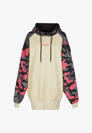 Beige hoodie met zwarte trekkoorden, met mouwen in een camouflagedesign in grijs en roze, en een voorste kangoeroezak.