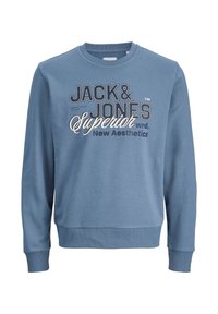 Μπλε βαμβακερό φούτερ με στρογγυλή λαιμόκοψη, μακριά μανίκια και ριμπ μανσέτες· διαθέτει εκτυπωμένη μάρκα σε αντίθετα χρώματα στην πρόσοψη.