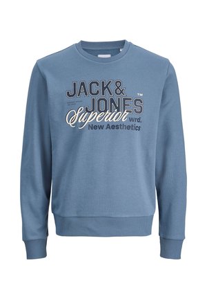 Zils kokvilnas džemperis ar apaļo izgriezumu, garām piedurknēm un ribotiem aprocēm; priekšpusē krāsās kontrastējoša drukāta zīmola apdare.