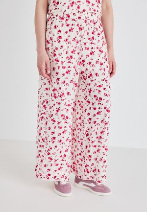 Vide bukser i hvide stoffer med pink blomsterprint, der har et plisseret design og elastisk talje. Kombinationen med pink sneakers.