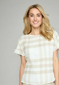 Kortærmet linned top med et lys beige og hvidt stribet mønster, afslappet pasform og tekstureret detalje over stoffet.