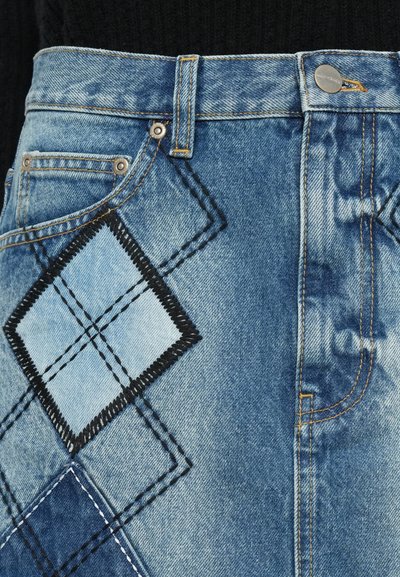 Falda de mezclilla en azul claro con un patrón de diamante y costuras negras. Detalles incluidos: botón plateado y costuras amarillas en contraste.