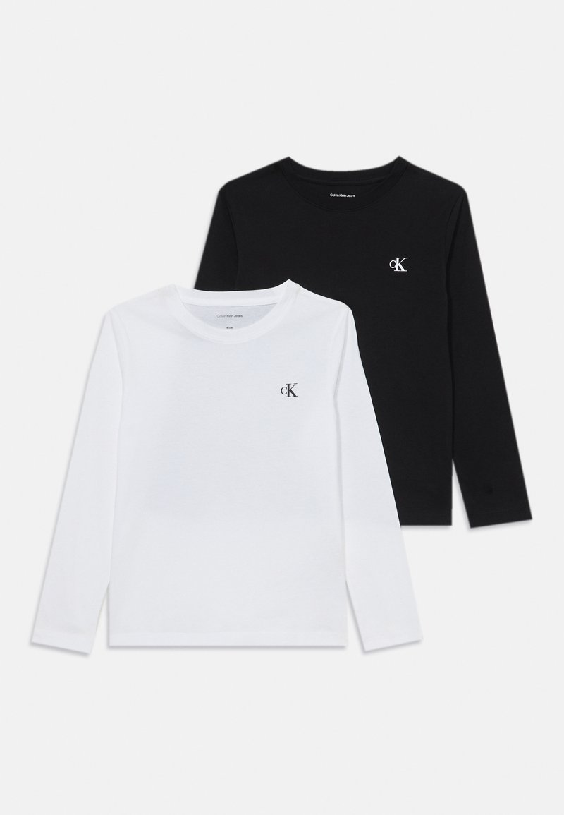 To langermede T-skjorter i hvit og svart bomull, med en liten "ck" logo på brystet, rund hals og enkelt design.