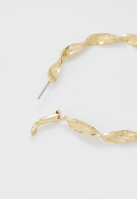 Gold twisted earrings featuring a textured surface with a shiny finish, complemented by a secure hook fastener.