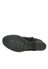 Botte noire avec une semelle en caoutchouc texturé présentant un motif de semelle. Comprend une fermeture éclair et un upper en cuir cousu. Durable et robuste.