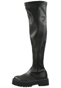 Bottes noires en simili cuir arrivant au genou, avec une semelle plate et épaisse et des détails sur les coutures latérales. Texture lisse avec un design élégant et ajusté.