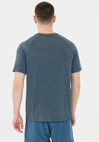 Kortärmad herrtröja i atletisk stil av melerad mörkblå tyg, med en klassisk passform och slät textur samt raglanärmar.