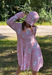 Vaaleanpunainen pitkähihaista mekko ja siihen sopiva hattu, molemmissa on pupugrafiikoita ja sydämiä. Pehmeä kangas, polven mittainen muotoilu, leikkisiä kuvioita.