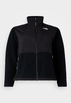 Zwarte jas met een combinatie van gladde stof en gestructureerde fleece. Hoge kraag, ritsopening en zijzakken zijn zichtbaar.