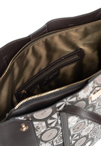 Wnętrze brązowej skórzanej torebki o satynowym wykończeniu, z kieszenią na zamek i miejscem na karty, otoczone wzorzystą zewnętrzną powierzchnią.