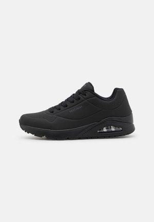Czarny sportowy sneaker Skechers z sznurowadłami, amortyzowaną podeszwą, pianką powietrzną na pięcie oraz perforowanymi detalami na cholewce i kołnierzu.