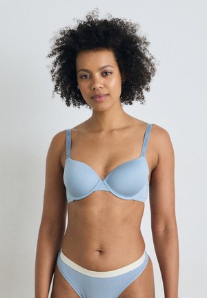 Lyseblå bh med glatt stoff og undertråd. Justerbare stropper med merkeinformasjon. Kombinert med matchende bikinioverbukser med hvit midjebånd.