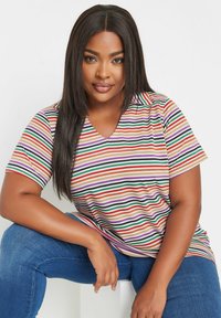 Randig t-shirt med V-hals i färger som orange, grön, lila och beige. Mjuk tyg, avslappnad passform och korta ärmar.