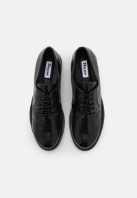 Chaussures noires à lacets avec un motif texturé en peau de serpent, fabriquées en matériau synthétique, dotées d'un bout arrondi et d'une semelle plate.