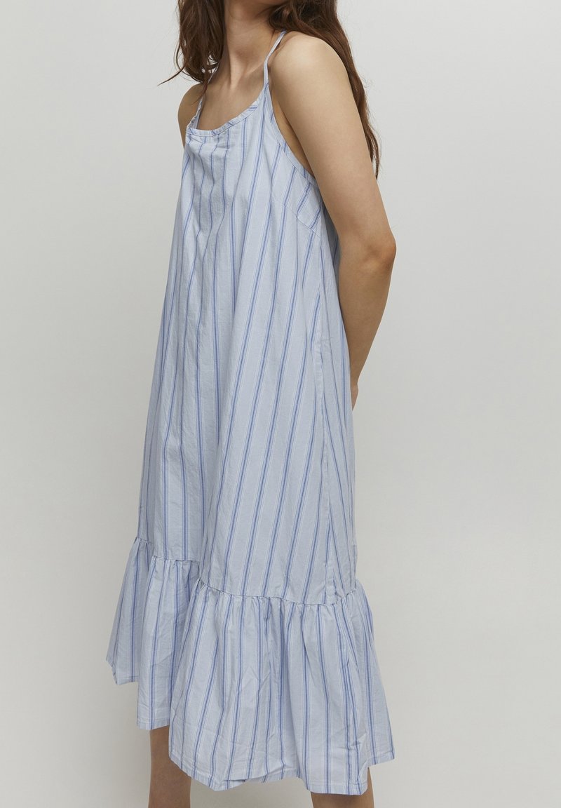 Blå och vit randig ärmlös klänning med volangkant, tillverkad av lätt tyg, med tunna remmar och avslappnad passform.