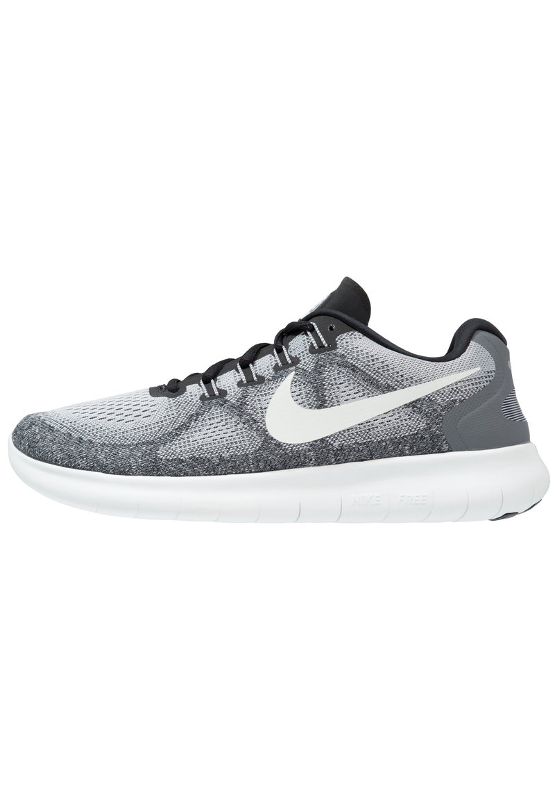 Scarpa da running Nike grigia e nera con logo swoosh bianco, lacci neri e suola bianca spessa, mostrata in profilo laterale su sfondo bianco.