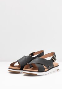 UGG Sandaalit nilkkaremmillä - black