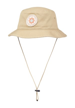 Beżowy kapelusz typu bucket z szerokim rondem, regulowanym paskiem pod brodą oraz okrągłą naszywką z motywem słońca i tekstem z przodu.