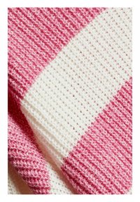 Acercamiento a una suave tela de punto con franjas horizontales alternas de color rosa y blanco, y un patrón texturizado similar al de un gofre.