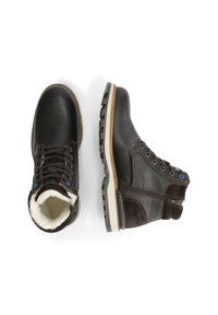 Bruine leren enkelboots met een gestructureerde afwerking, een lichtgekleurde zool en een voering van bont. Voorzien van blauwe oogjes en zijritsen voor sluiting.