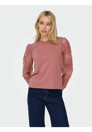 Top rose avec un corps uni et des manches transparentes brodées de fleurs. Les manches ont une texture délicate et des détails de conception bouffants.