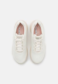 Scarpe sportive in rete bianche con accenti beige chiaro, dotate di sei fori per i lacci, lacci piatti e una suola testurizzata con l'etichetta "ArchFit" e "Air-Cooled".