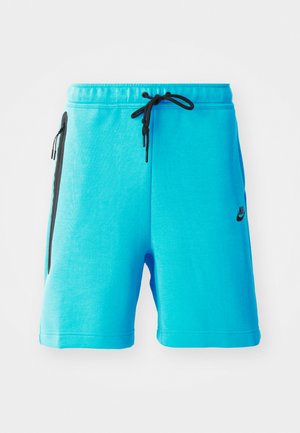 Nike modre hlače iz mehkega materiala, ki imajo pas z vrvico, stranske žepke z črnimi detajli in majhen črn logo.