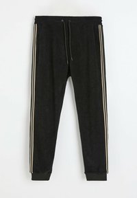 Czarne dresy z teksturowanej tkaniny, z beżowymi paskami po bokach, elastyczną talią ze sznurkiem i ściągaczami na kostkach.