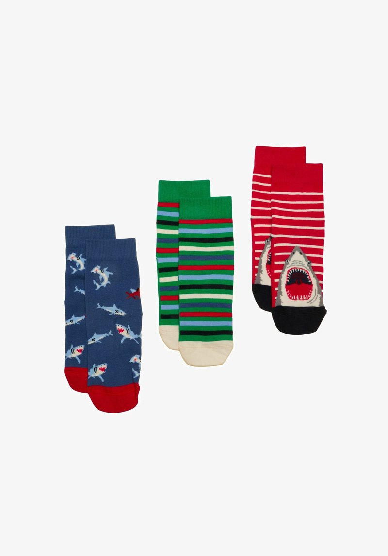 Trois paires de chaussettes colorées : bleues avec un motif requin et poisson, vertes avec des rayures multicolores, rouges avec des rayures blanches et un motif de bouche de requin.