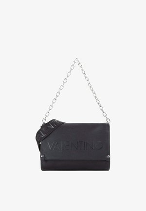 Sac à bandoulière Valentino noir avec logo embossé, bandoulière chaîne argentée et bandoulière en tissu de marque supplémentaire sur fond blanc.