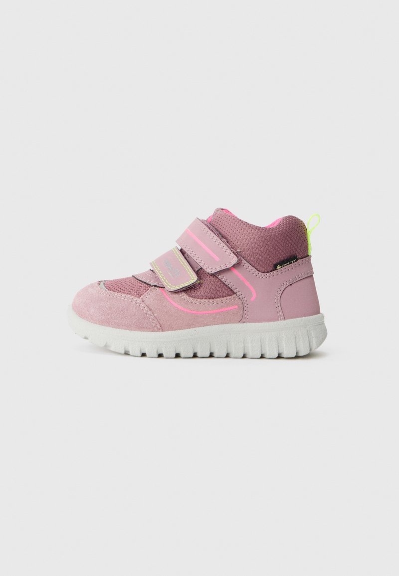 Pink children's shoe with suede and textile materials, featuring two Velcro straps, a round toe, and a textured white rubber sole.