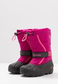 Bottes d'hiver isolées roses avec une semelle en caoutchouc noir imperméable, dotées d'un dessus en nylon, de lacets élastiques et d'une sangle en velcro avec logo.